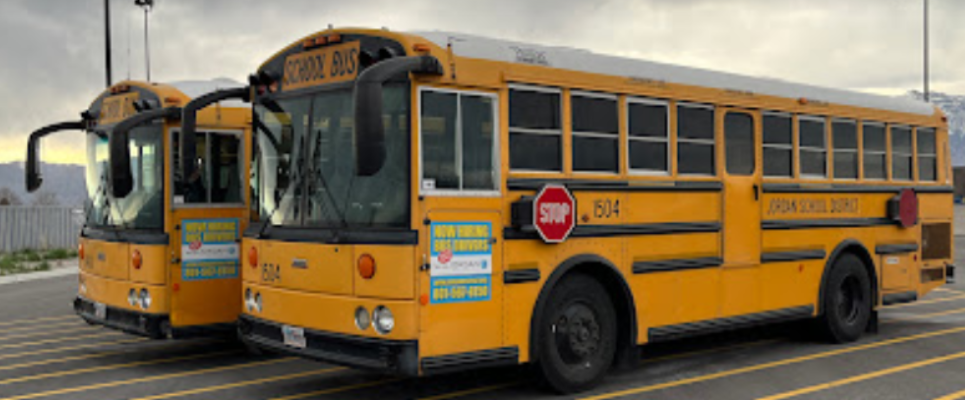 Fuel-efficient busses parked in a Jordan School District parking lot.